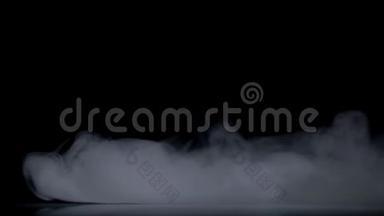 抽象<strong>烟雾</strong>云。 白色的<strong>烟雾</strong>在黑色的背景下慢慢地飘过空间。 雾效应。 大气<strong>烟雾</strong>